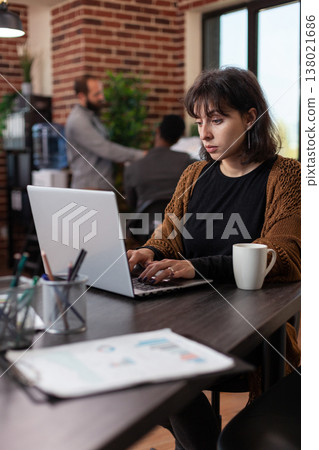 Entrepreneur woman analyzing company statistics typing marketing strategy on laptop computer working in startup office. Executive manager brainstorming ideas planning business collaboration Entrepreneur woman analyzing company statistics typing marketing strategy on laptop computer working in startup office. Executive manager brainstorming ideas planning business collaboration 138021686
