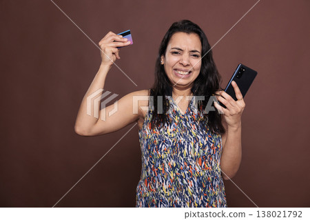 Stressed indian woman having ecommerce website checkout problem, buying product in online store, credit card trouble. Unsatisfied client making order, using internet shop application Stressed indian woman having ecommerce website checkout problem, buying product in online store, credit card trouble. Unsatisfied client making order, using internet shop application 138021792