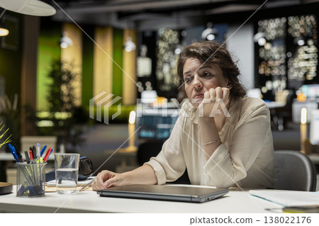 Demotivated businesswoman, sighing, pushing limits, late at night, being in a mental haze and troubled by workload and life choices. Uninterested tensed woman struggling with fatigue. 138022176