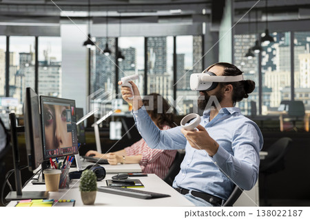 Editing photography, in virtual reality metaverse, editor retouching content, with VR headset in agency studio. Man doing image selection and editing photography for commercial catalog. 138022187