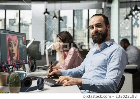 Portrait of employee editing photography on monitor with retouching software tools, color grading and image selection for editorial materials. Creative studio for commercial content. 138022198