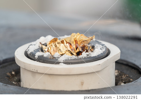 Gold leaf melting in a crucible during a refining process showing intense heat and transformation of precious metal. 138022291