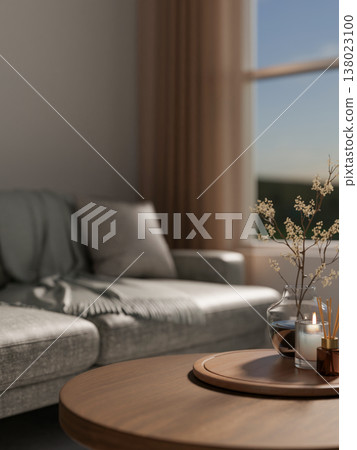 Flower vase and candle with diffuser on wooden tray at round table across sofa couch in living room. 138023100