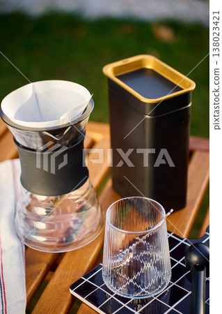 Specialty pour over coffee setup with dripper and glass outdoors Specialty pour over coffee setup with dripper and glass outdoors 138023421