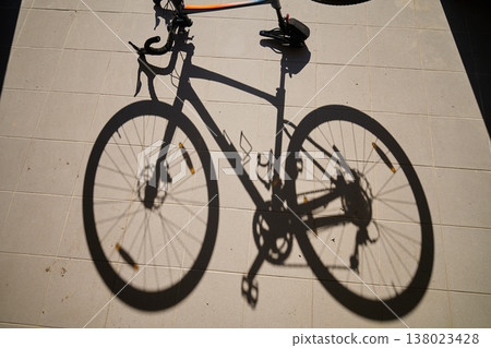 Shadow of bicycle on tiled garage floor in sunlight Shadow of bicycle on tiled garage floor in sunlight 138023428