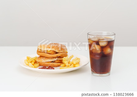 juicy beef burger with melted cheddar cheese, potato chips and carbonated Soft drinks on table. Unhealthy, High calorie, Fast food craving, Obesity, diet, weight loss, junk food and lifestyle 138023666