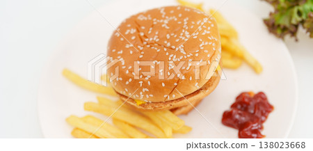 juicy beef burger with melted cheddar cheese, potato chips on table. Unhealthy, High calorie, Fast food craving, Obesity, diet, weight loss, junk food and lifestyle 138023668