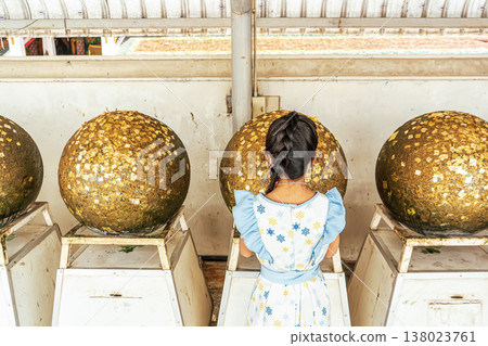 Girl facing golden spheres Girl facing golden spheres 138023761