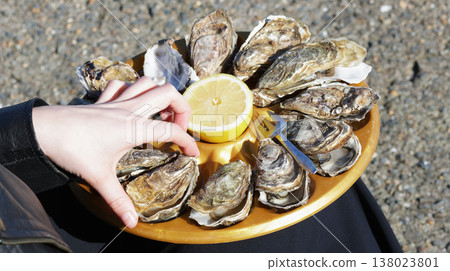 Close-up of a girl taking an oyster from a tray Close-up of a girl taking an oyster from a tray 138023801