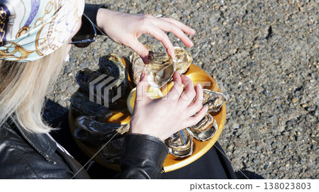 Close-up of a girl taking an oyster from a tray Close-up of a girl taking an oyster from a tray 138023803