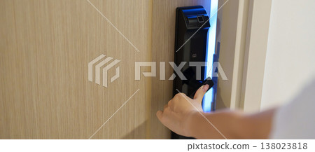 Hand using smart digital door lock while open or close the door at home or apartment. NFC Technology, Fingerprint scan, keycard, PIN number, smartphone, electrical and contactless lifestyle concepts 138023818