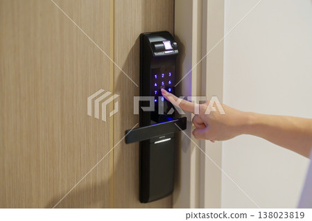 Hand press PIN number for smart digital door lock while open or close the door at home or apartment. NFC Technology, Fingerprint scan, keycard, smartphone and contactless lifestyle concepts 138023819