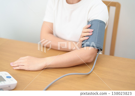 woman checking Blood pressure by Blood pressure monitor with Cuff. Systolic, SYS, Diastolic, DIA, Pulse, Hypertension, Hypotension, Heart rate, Cardiovascular Disease and May World hypertension day 138023823