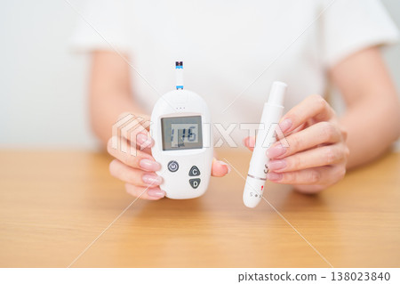 Hand checking Diabetes or Blood glucose self testing by digital blood glucose meter with lancet pen. high blood sugar level, World Diabetes Day, Glycemia, Hypoglycemia, Hyperglycemia and insulin Hand checking Diabetes or Blood glucose self testing by digital blood glucose meter with lancet pen. high blood sugar level, World Diabetes Day, Glycemia, Hypoglycemia, Hyperglycemia and insulin 138023840