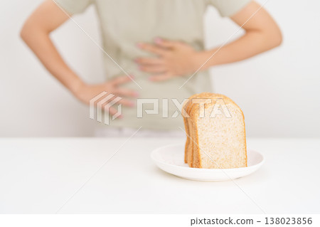 Gluten intolerance, Gluten free and celiac disease or Wheat allergy. woman with wheat bread and having abdominal pain after eat gluten. stomach ache, Nausea, Bloating, Gas, Diarrhea and Skin rash 138023856