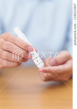 Hand using lancet pen on finger with Blood drop glucose testing or Diabetes checking by digital blood glucose meter. blood sugar level, Diabetes Day, Glycemia, Hypoglycemia, Hyperglycemia and insulin Hand using lancet pen on finger with Blood drop glucose testing or Diabetes checking by digital blood glucose meter. blood sugar level, Diabetes Day, Glycemia, Hypoglycemia, Hyperglycemia and insulin 138023907