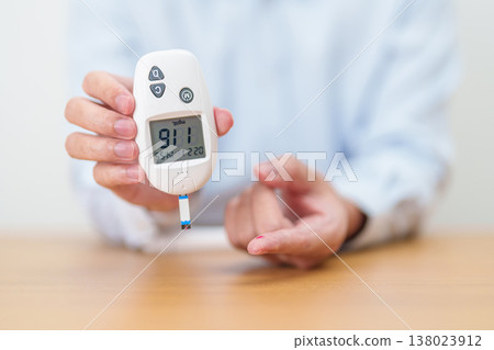 Hand checking Diabetes or Blood glucose self testing by digital blood glucose meter with lancet pen. high blood sugar level, World Diabetes Day, Glycemia, Hypoglycemia, Hyperglycemia and insulin Hand checking Diabetes or Blood glucose self testing by digital blood glucose meter with lancet pen. high blood sugar level, World Diabetes Day, Glycemia, Hypoglycemia, Hyperglycemia and insulin 138023912