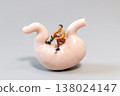 Miniature Man Sitting on Human Stomach Model with Bottle Concept of Alcohol and Digestive Health 138024147