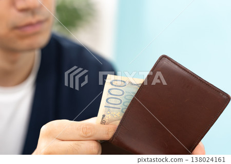 A man short on cash; his wallet is in his hand. A man short on cash; his wallet is in his hand. 138024161