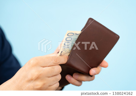 A man short on cash; his wallet is in his hand. A man short on cash; his wallet is in his hand. 138024162