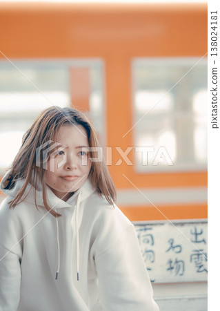 一位二十多歲的女性坐在火車站長椅上的肖像。 138024181