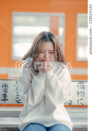 一位二十多歲的女性坐在火車站長椅上的肖像。 一位二十多歲的女性坐在火車站長椅上的肖像。 138024183