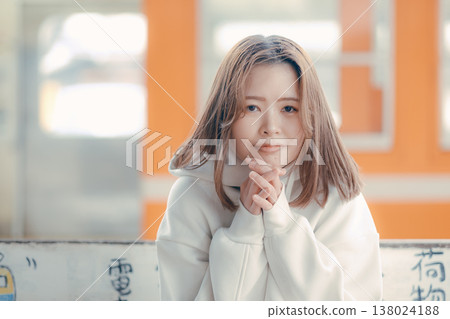 一位二十多歲的女性坐在火車站長椅上的肖像。 一位二十多歲的女性坐在火車站長椅上的肖像。 138024188