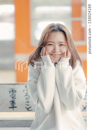 一位二十多歲的女性坐在火車站長椅上的肖像。 一位二十多歲的女性坐在火車站長椅上的肖像。 138024189