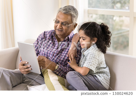 Elderly 70s great-grandpa and little 6s grandkid using tablet Elderly 70s great-grandpa and little 6s grandkid using tablet 138024620