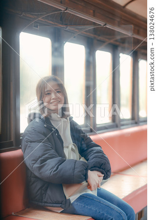 Portrait of a woman in her 20s waiting on a train with her bag in hand. 138024676