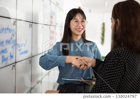 Happy Asian business leader woman shaking hands with partner Happy Asian business leader woman shaking hands with partner 138024797