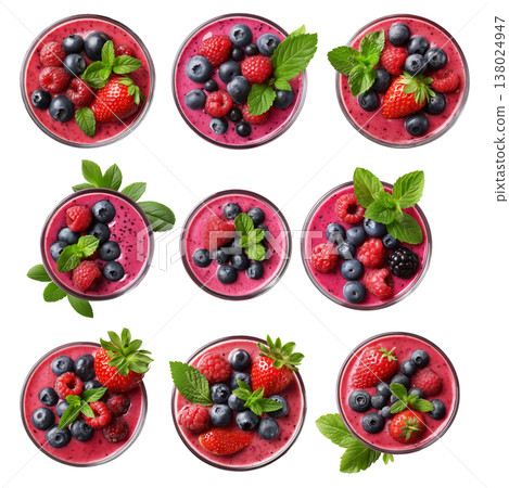 Glass bowl filled with mixed berry smoothie topped with blueberries, raspberries, strawberry, and mint leaves on white 138024947