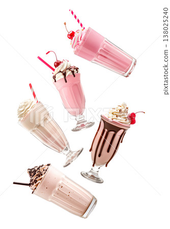 Multiple milkshakes with whipped cream shown isolated on white background, concept of sweet dessert treats Multiple milkshakes with whipped cream shown isolated on white background, concept of sweet dessert treats 138025240