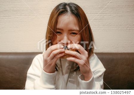 一位二十多歲的微笑的女子正在吃飯團。 一位二十多歲的微笑的女子正在吃飯團。 138025497