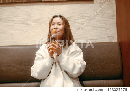 Portrait of a woman in her 20s holding a plastic bottle of tea. Portrait of a woman in her 20s holding a plastic bottle of tea. 138025576