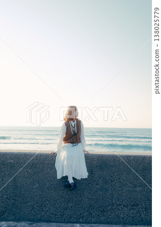 一位年輕女子在海灘上手持相機的肖像 一位年輕女子在海灘上手持相機的肖像 138025779