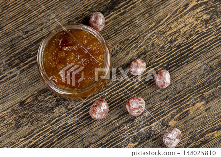 orange jam made from oranges and fresh citrus fruits, orange jam with dried kumquat fruits in sweet syrup, jam for making desserts in a round glass jar on a wooden table orange jam made from oranges and fresh citrus fruits, orange jam with dried kumquat fruits in sweet syrup, jam for making desserts in a round glass jar on a wooden table 138025810