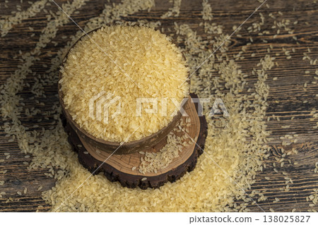 white dry hard rice, poured before cooking, poured natural pure polished rice on the table before cooking, The rice is poured into a bowl made from coconut shells white dry hard rice, poured before cooking, poured natural pure polished rice on the table before cooking, The rice is poured into a bowl made from coconut shells 138025827