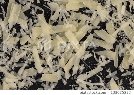 hard ripe cheese grated into pieces for cooking pasta or pizza, grated piece of yellow quality cheese as an ingredient for a large dish 138025853