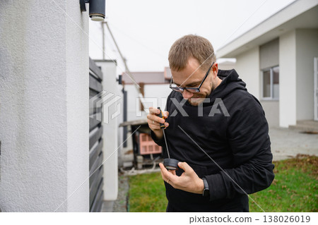 Man assembling outdoor light fixture with screwdriver Man assembling outdoor light fixture with screwdriver 138026019