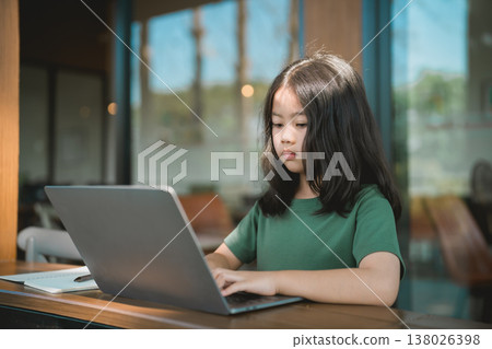 Young girl with long hair focused on laptop in modern cafe setting, creating project and exploring digital world under natural light Young girl with long hair focused on laptop in modern cafe setting, creating project and exploring digital world under natural light 138026398