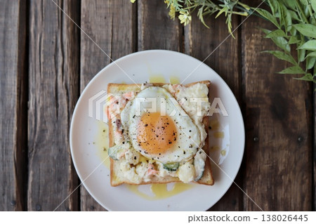 Open-faced sandwich with potato salad drizzled in olive oil and a fried egg. Open-faced sandwich with potato salad drizzled in olive oil and a fried egg. 138026445