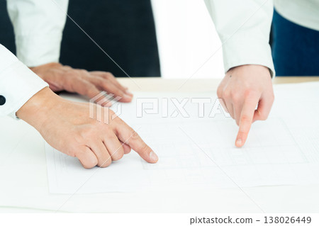 The hands of a man and a woman in work clothes looking at blueprints The hands of a man and a woman in work clothes looking at blueprints 138026449