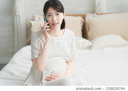 A pregnant woman calling the hospital after her water breaks Lifestyle image A pregnant woman calling the hospital after her water breaks Lifestyle image 138026744