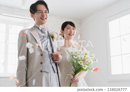 新娘和新郎接受鮮花雨的婚禮照片 新娘和新郎接受鮮花雨的婚禮照片 138026777
