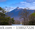 北海道駒嶽山，仍覆蓋著積雪，聳立在湖邊的森林外（北海道大沼市七江町）。 138027226