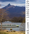 A white pleasure boat crosses the lake with the snow-capped Mount Komagatake in the background (Onuma, Nanae Town, Hokkaido). A white pleasure boat crosses the lake with the snow-capped Mount Komagatake in the background (Onuma, Nanae Town, Hokkaido). 138027229