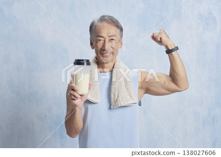 一位老年男子手持蛋白粉瓶進行訓練，並揮拳慶祝。 138027606