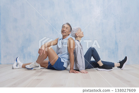 一對身著運動服的老夫婦悠閒地坐著 138027609