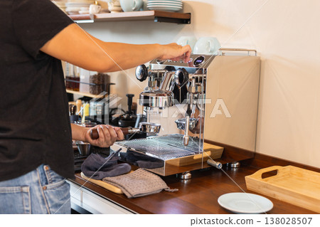 Barista preparing espresso by flushing the group head on espresso machine. Barista preparing espresso by flushing the group head on espresso machine. 138028507